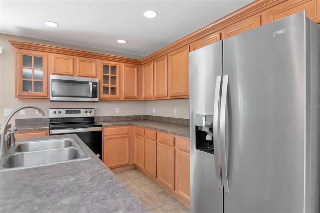 6952 Marble Fawn Place Riverview, FL 33578 - Photo 16 of 42 a kitchen with stainless steel appliances granite countertop a refrigerator stove microwave and sink