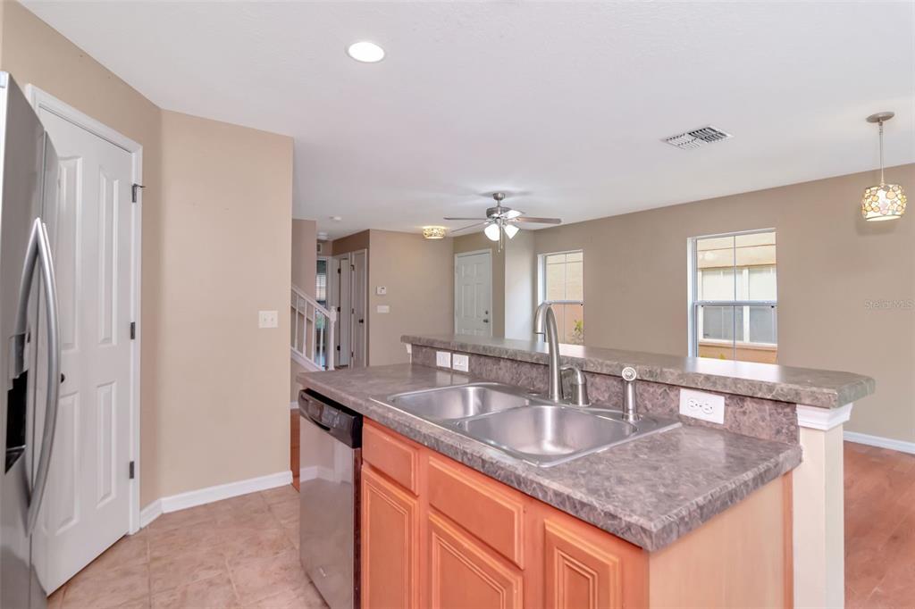 6952 Marble Fawn Place Riverview, FL 33578 - Photo 18 of 42 a kitchen with granite countertop a sink and dishwasher with wooden floor