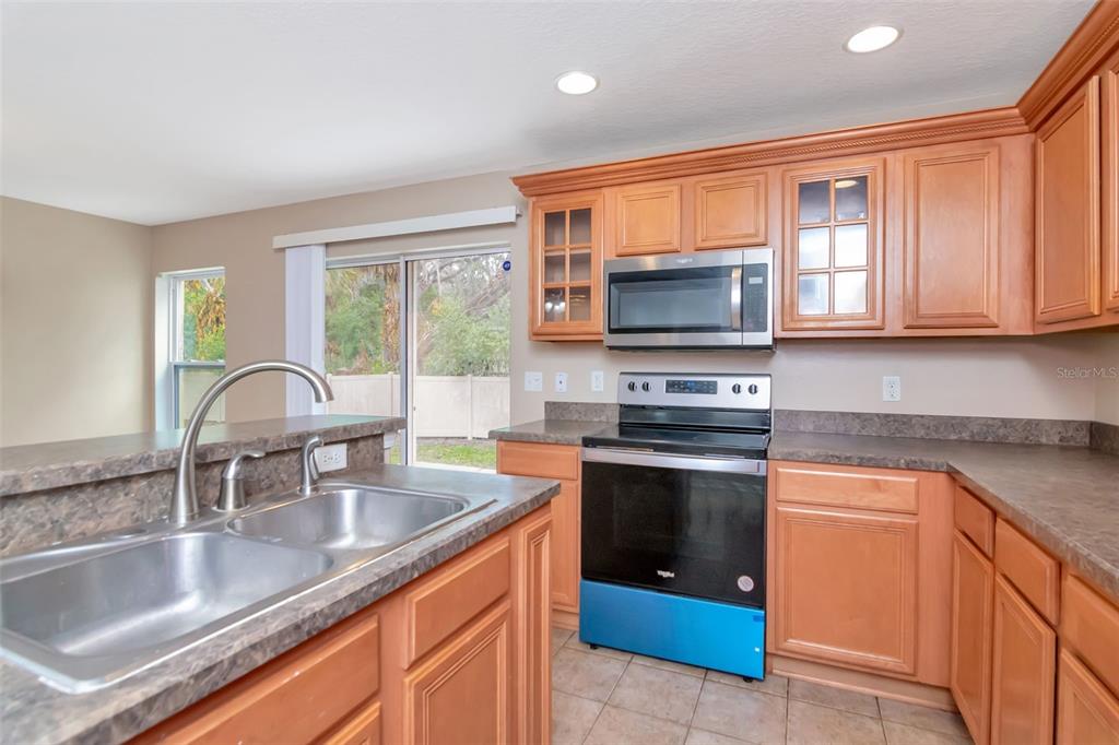 6952 Marble Fawn Place Riverview, FL 33578 - Photo 19 of 42 a kitchen with granite countertop a sink and a stove top oven