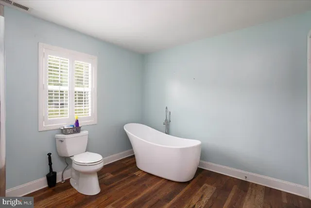 a bathroom with a toilet and a window