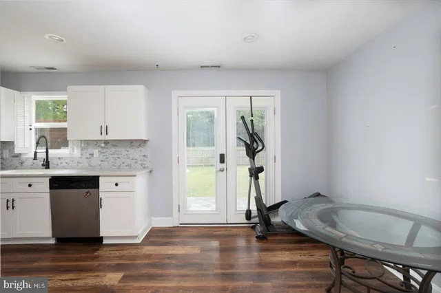 a kitchen with a sink cabinets and wooden floor