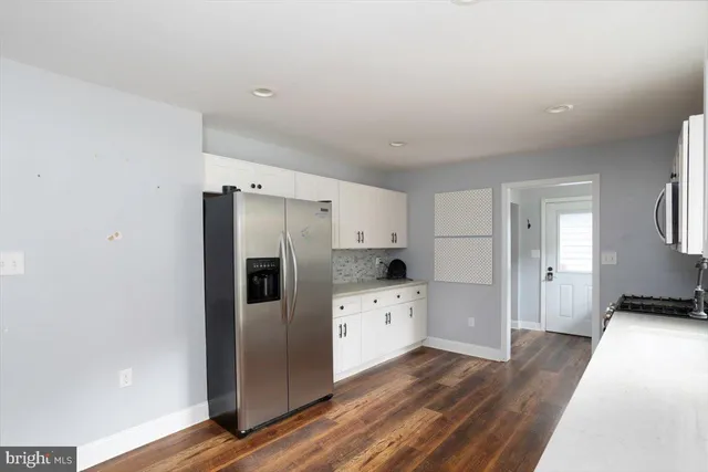 a kitchen with stainless steel appliances a refrigerator and wooden floor