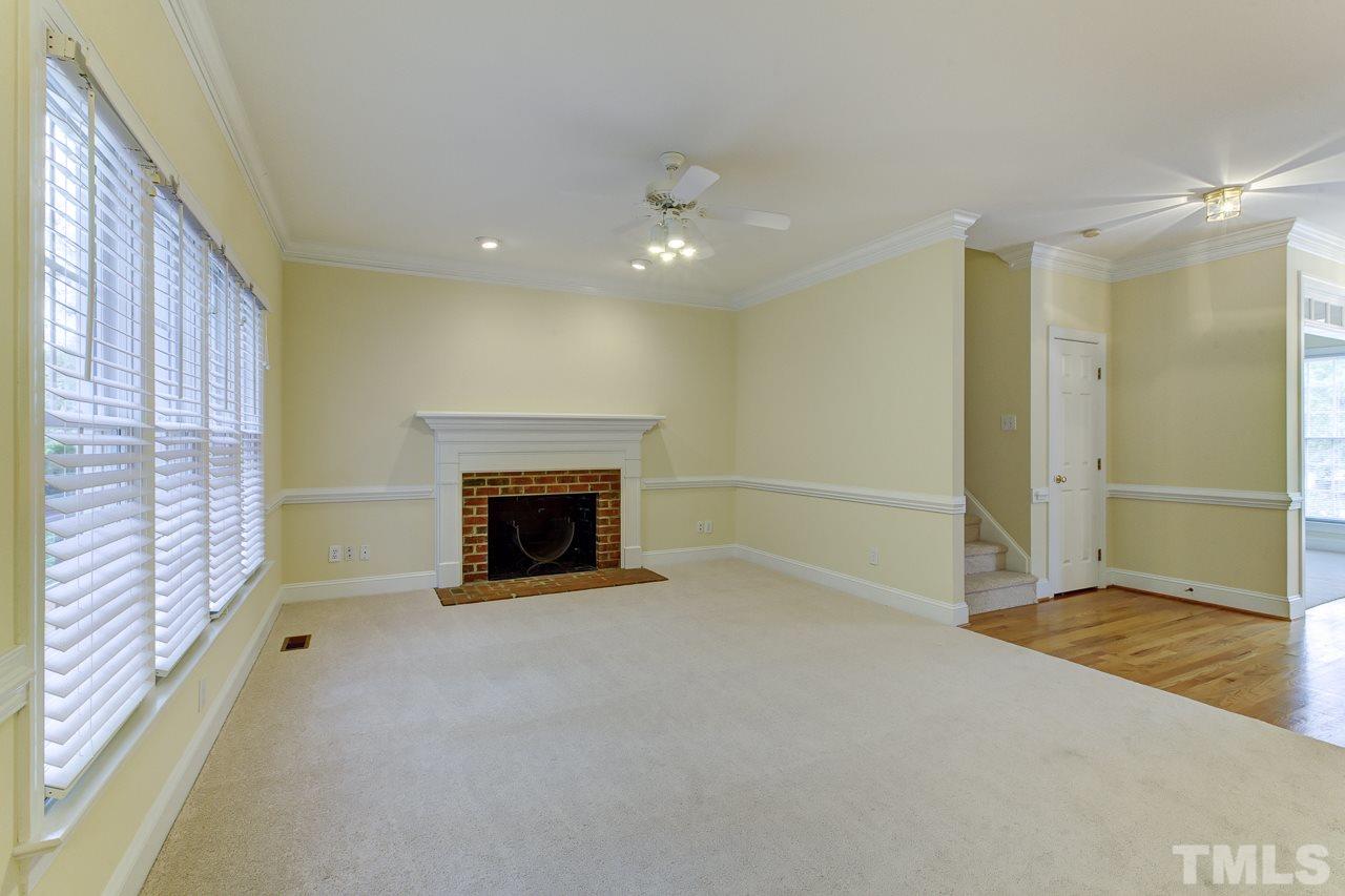 6805 Wilderness Road Raleigh, NC 27613 - Photo 12 of 25 a view of an empty room with a fireplace and a window