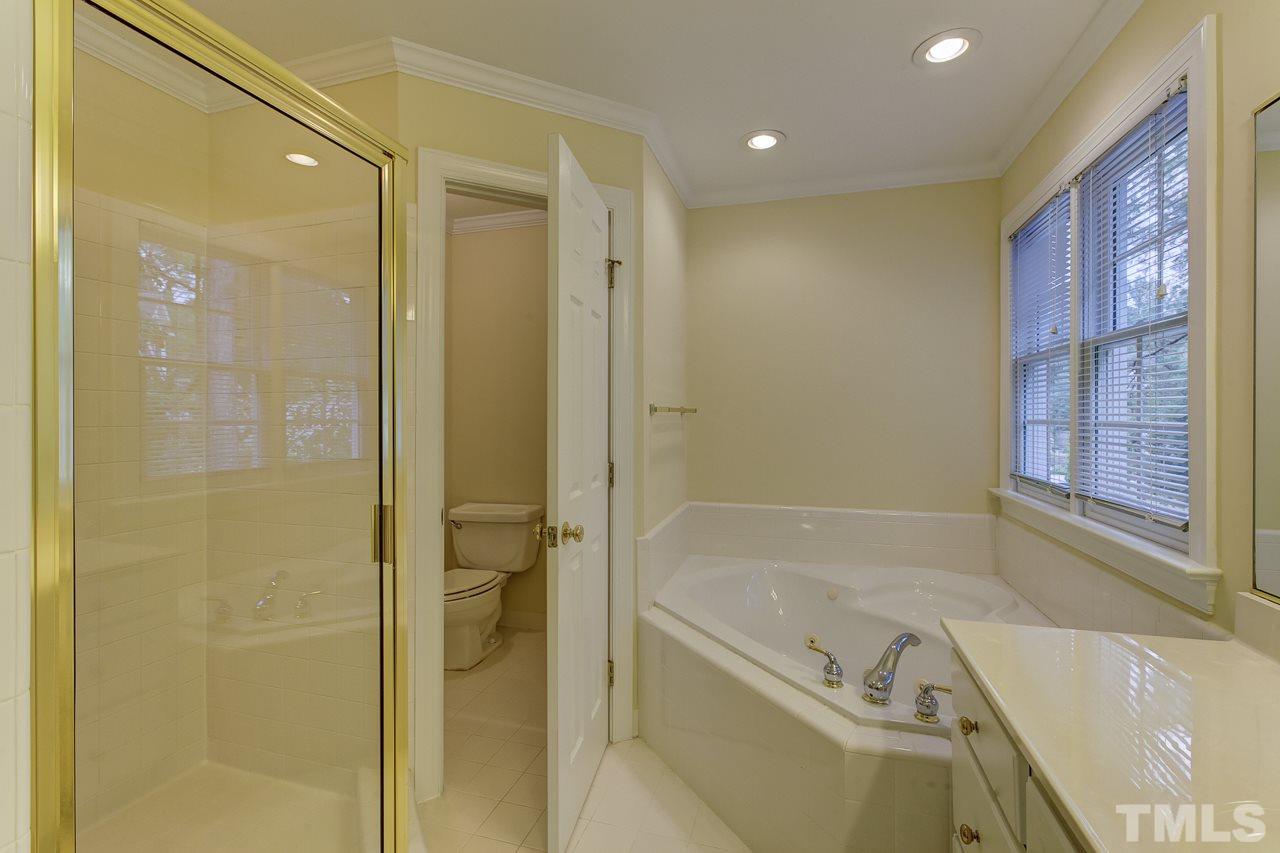6805 Wilderness Road Raleigh, NC 27613 - Photo 15 of 25 a bath room with a bath tub and shower