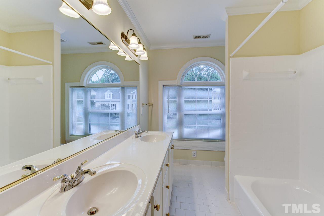 6805 Wilderness Road Raleigh, NC 27613 - Photo 19 of 25 a bathroom with a sink a large mirror and a shower