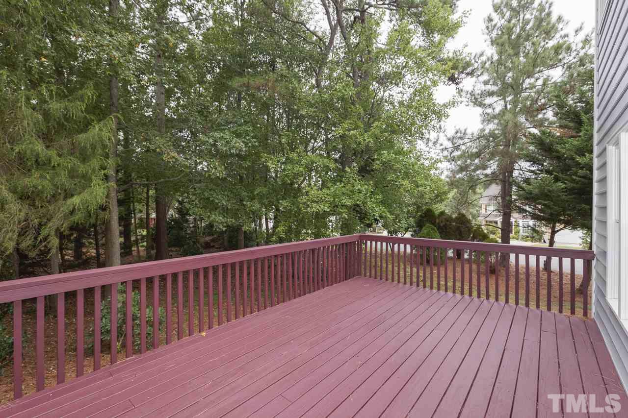6805 Wilderness Road Raleigh, NC 27613 - Photo 24 of 25 a balcony with wooden floor and trees in the back