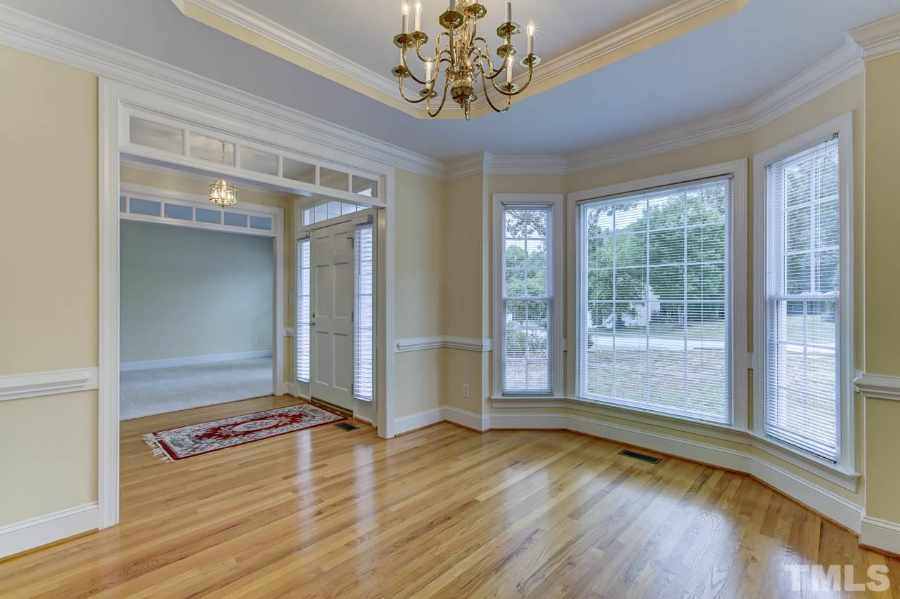 6805 Wilderness Road Raleigh, NC 27613 - Photo 4 of 25 a view of an empty room with wooden floor and a window