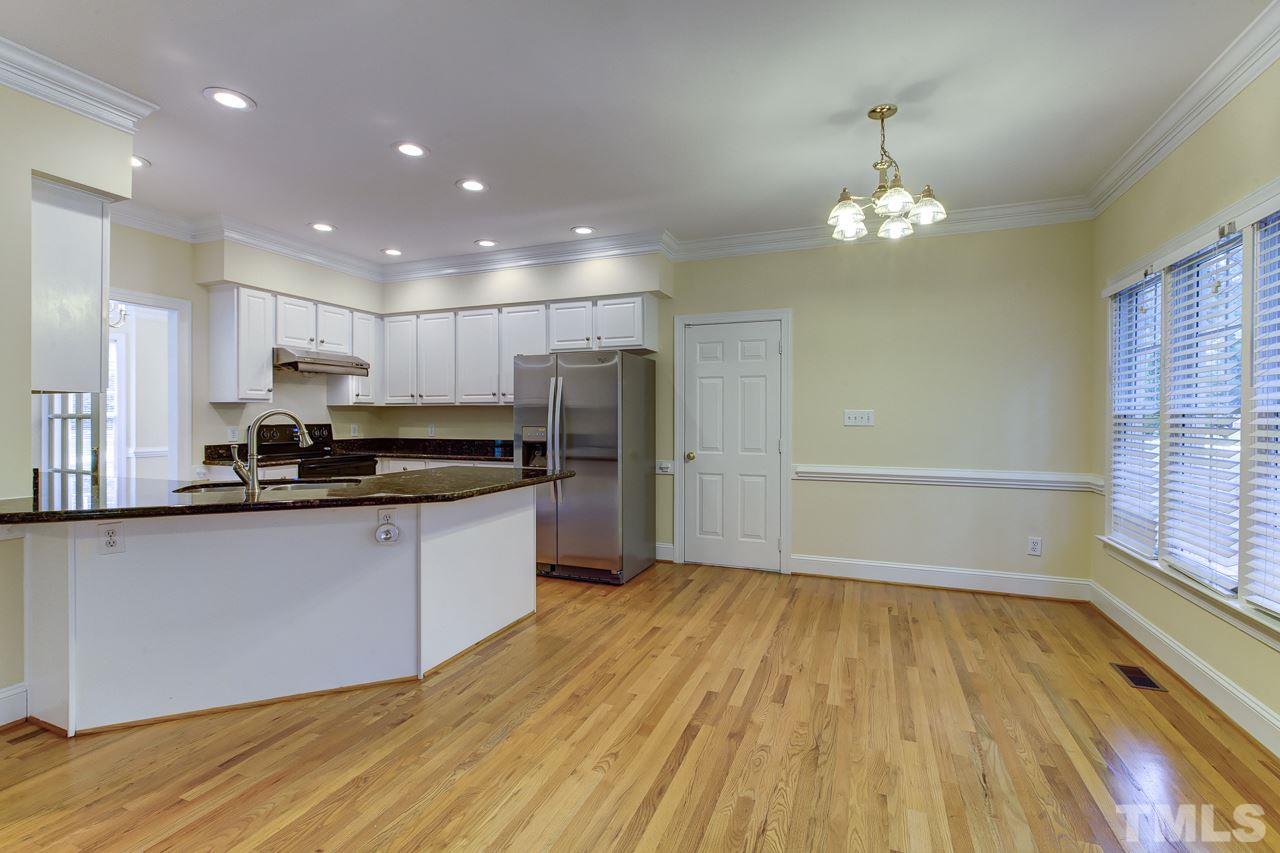 6805 Wilderness Road Raleigh, NC 27613 - Photo 6 of 25 a large kitchen with stainless steel appliances a large counter top a sink and a refrigerator