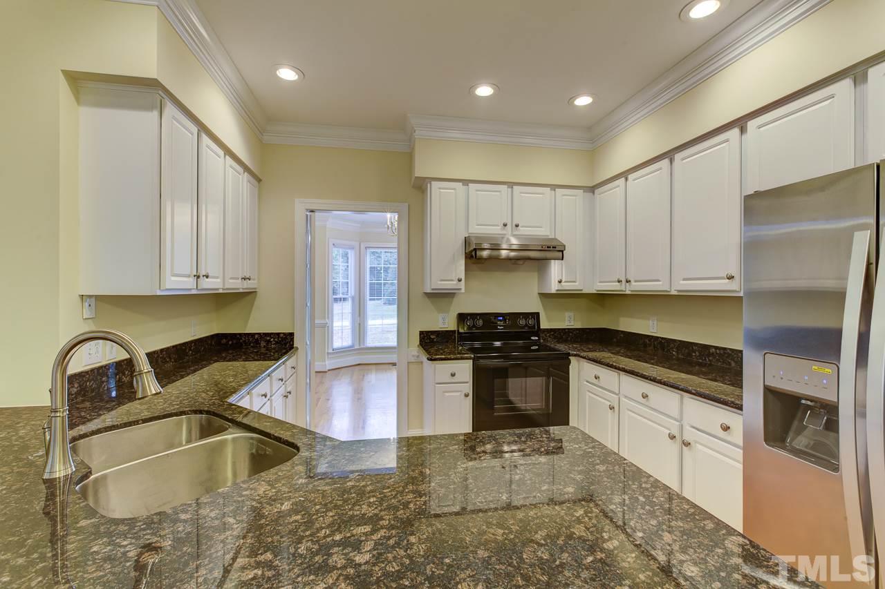 6805 Wilderness Road Raleigh, NC 27613 - Photo 7 of 25 a kitchen with stainless steel appliances granite countertop a sink stove and refrigerator