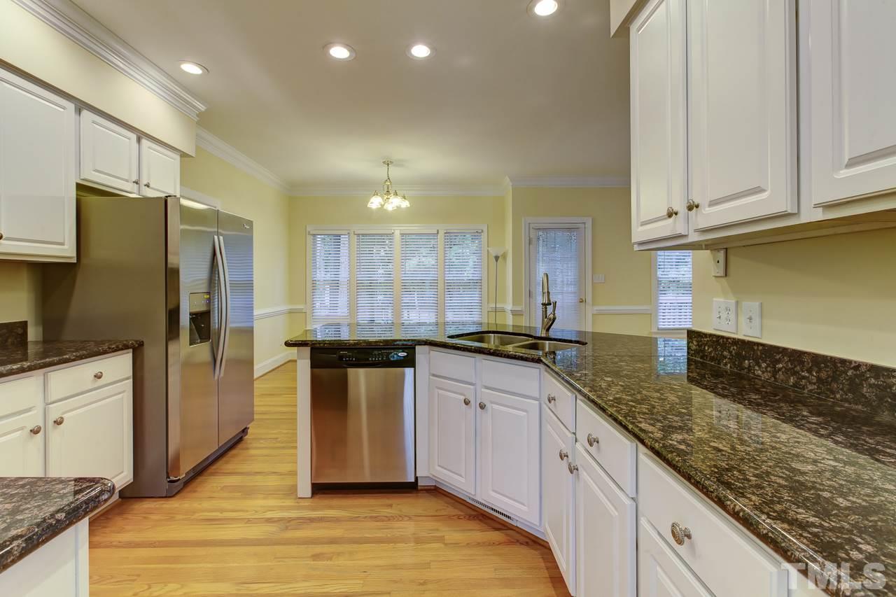 6805 Wilderness Road Raleigh, NC 27613 - Photo 8 of 25 a kitchen with stainless steel appliances granite countertop a sink a stove and a refrigerator