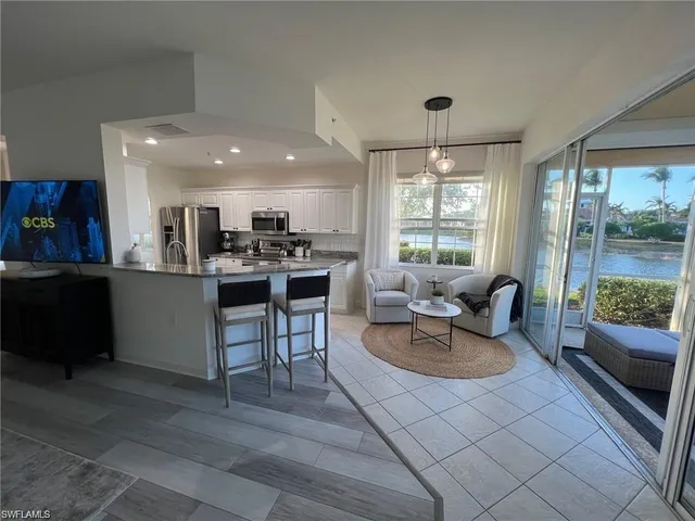 a kitchen with a table chairs microwave and cabinets