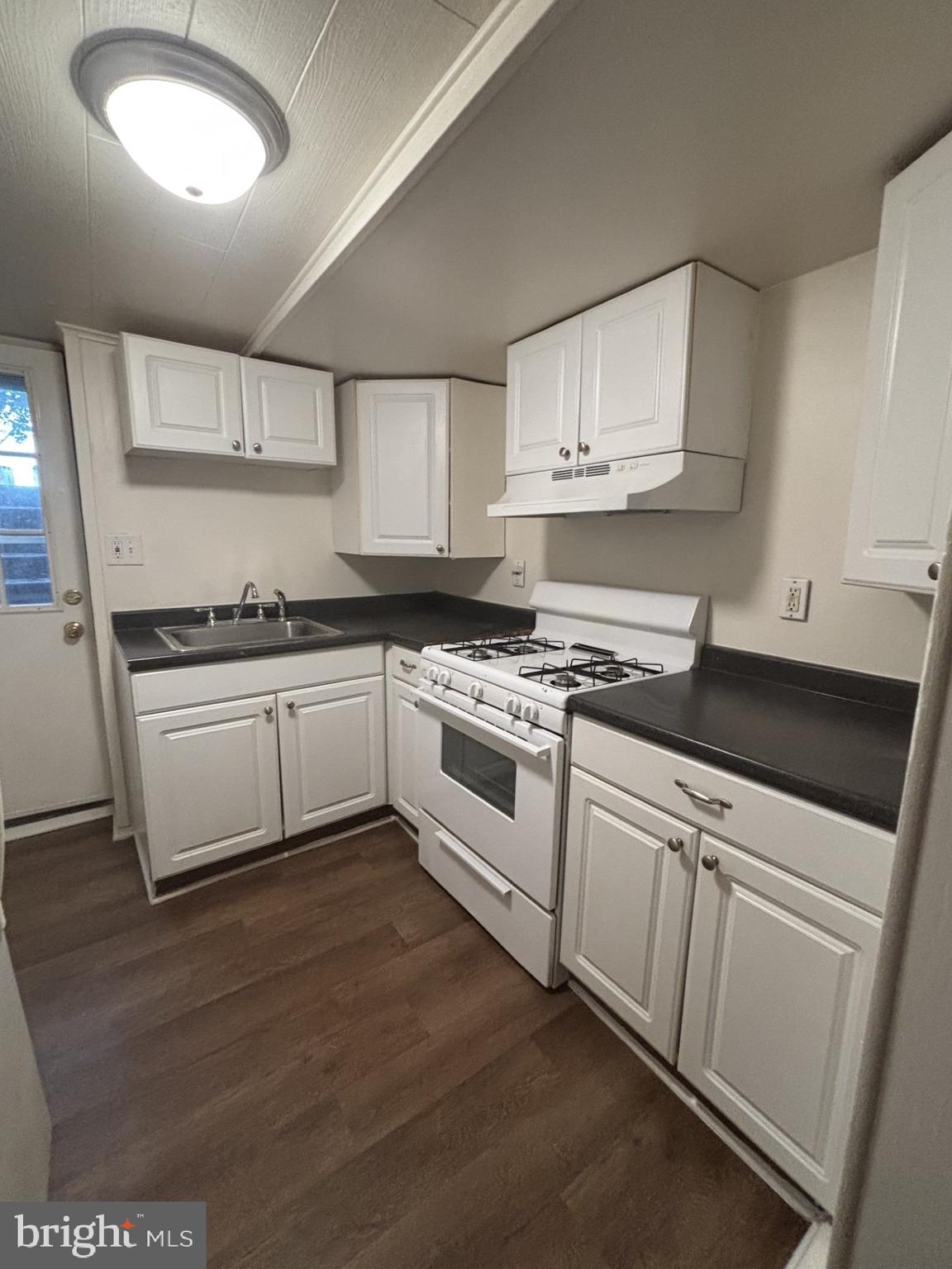 a white kitchen with sink and cabinets