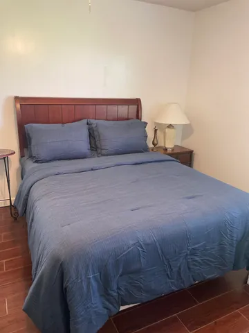 a bed sitting in a bedroom next to a lamp