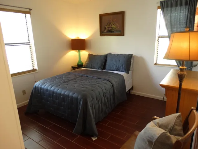 a bed sitting in a bedroom next to a window