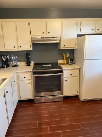 a kitchen with a stove and a white cabinet