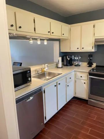a kitchen with granite countertop cabinets stainless steel appliances and a sink