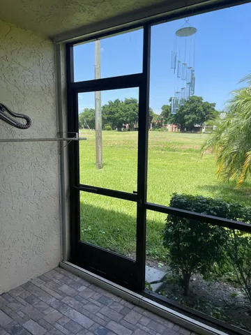 a view of a room that has a large window with wooden floor