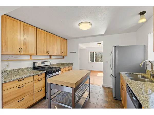 a kitchen with granite countertop a sink stove and cabinets
