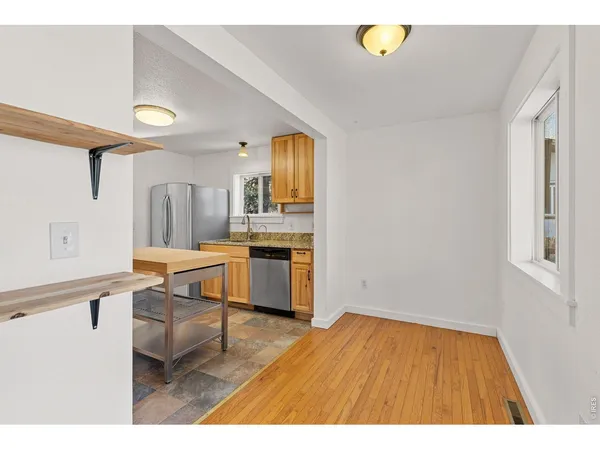a kitchen with a wooden floor and a refrigerator