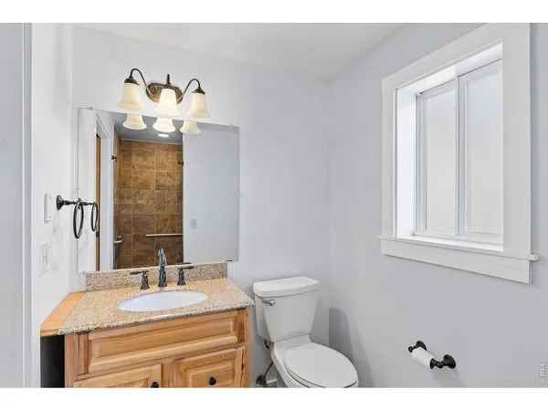 a bathroom with a sink mirror and toilet