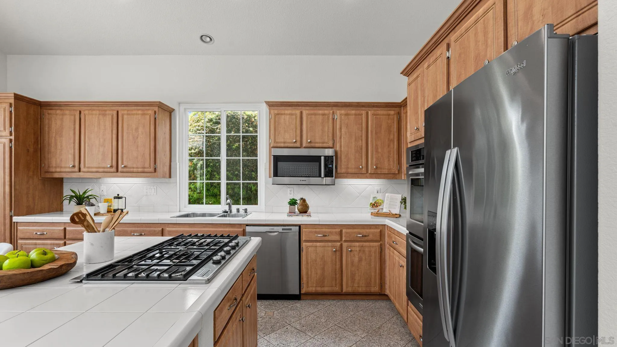 1783 Medinah Road San Marcos, CA 92069 - Photo 10 of 39 a kitchen with stainless steel appliances granite countertop a sink stove refrigerator and microwave