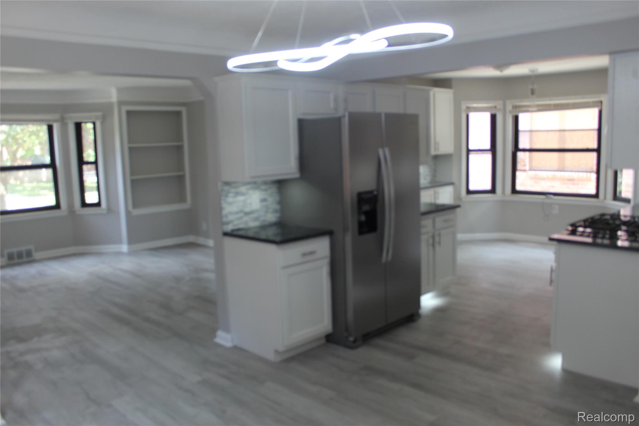 5543 Balfour Road Detroit, MI 48224 - Photo 23 of 54 Kitchen featuring a stainless steel refrigerator, white cabinetry, dark countertops, and a decorative tile backsplash