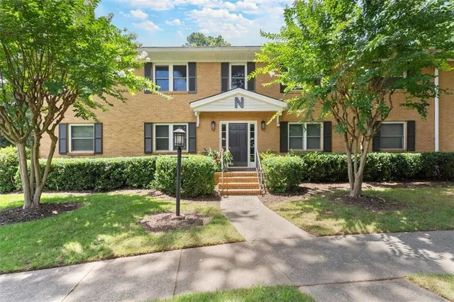 a front view of a house with a yard and potted plants