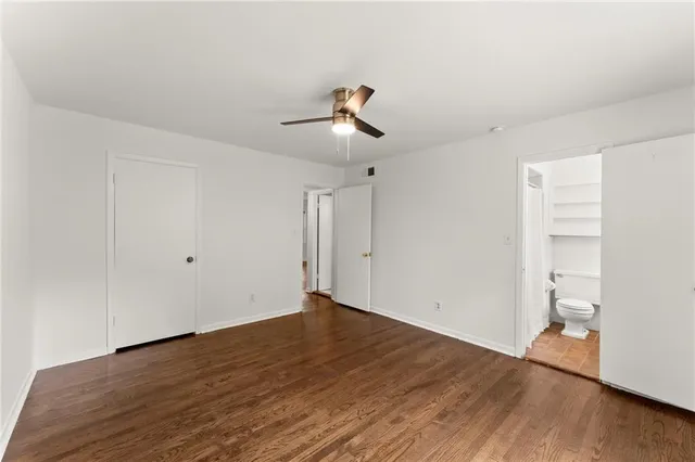 a view of a room with wooden floor and ceiling fan