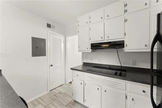a kitchen with white cabinets and black appliances