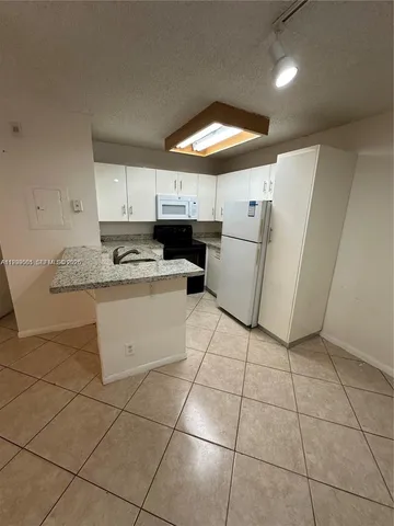 a kitchen with a sink a stove a refrigerator and cabinets
