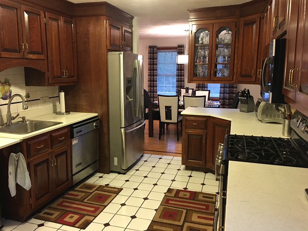 197 Acropolis Road Lowell, MA 01854 - Photo 14 of 29 a kitchen with a sink a stove and cabinets