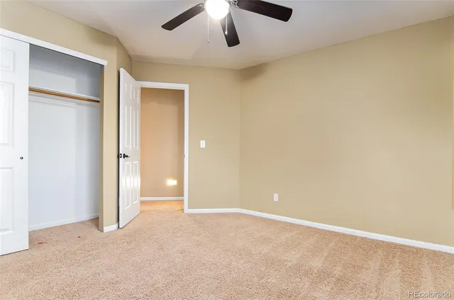 an empty room with chandelier fan