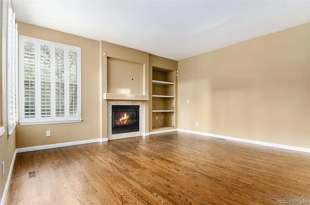 a view of an empty room with a fireplace and a window
