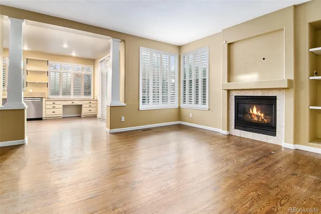 a view of a livingroom with furniture a fireplace and wooden floor