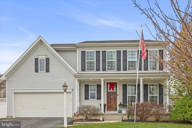 a view of a white house with large windows and a yard