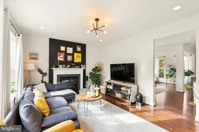 a living room with stainless steel appliances kitchen island granite countertop furniture and a rug