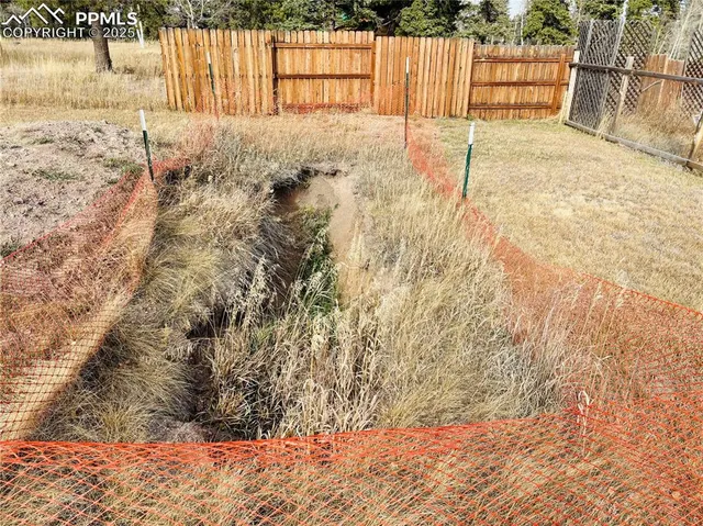 a view of backyard with wooden fence