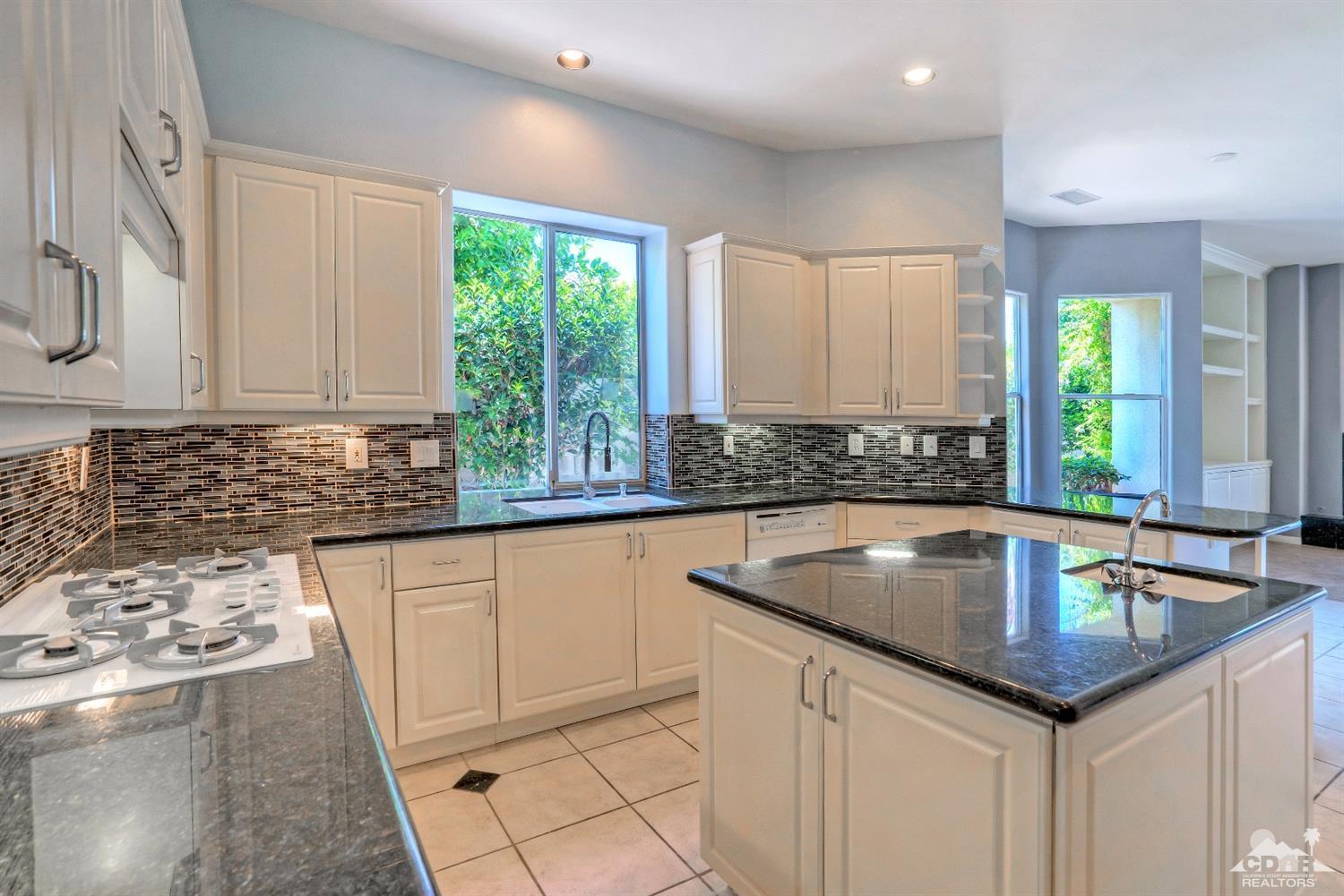 52 Sherwood Road Rancho Mirage, CA 92270 - Photo 11 of 25 a kitchen with granite countertop a sink window and cabinets