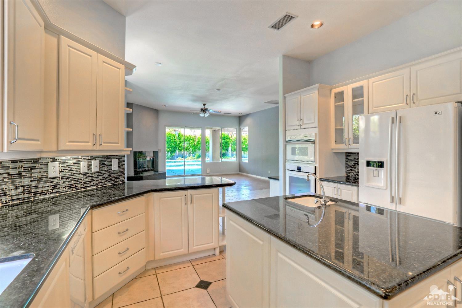 52 Sherwood Road Rancho Mirage, CA 92270 - Photo 12 of 25 a kitchen with granite countertop a sink a counter top space and stainless steel appliances