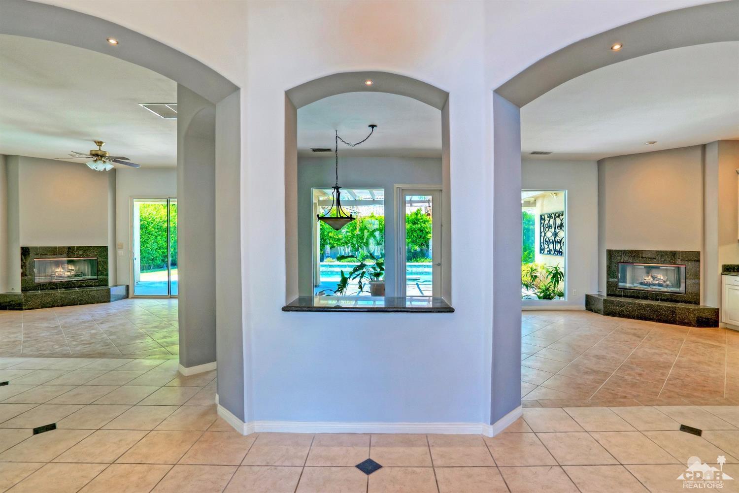 52 Sherwood Road Rancho Mirage, CA 92270 - Photo 4 of 25 a view of a hallway with windows and a fireplace