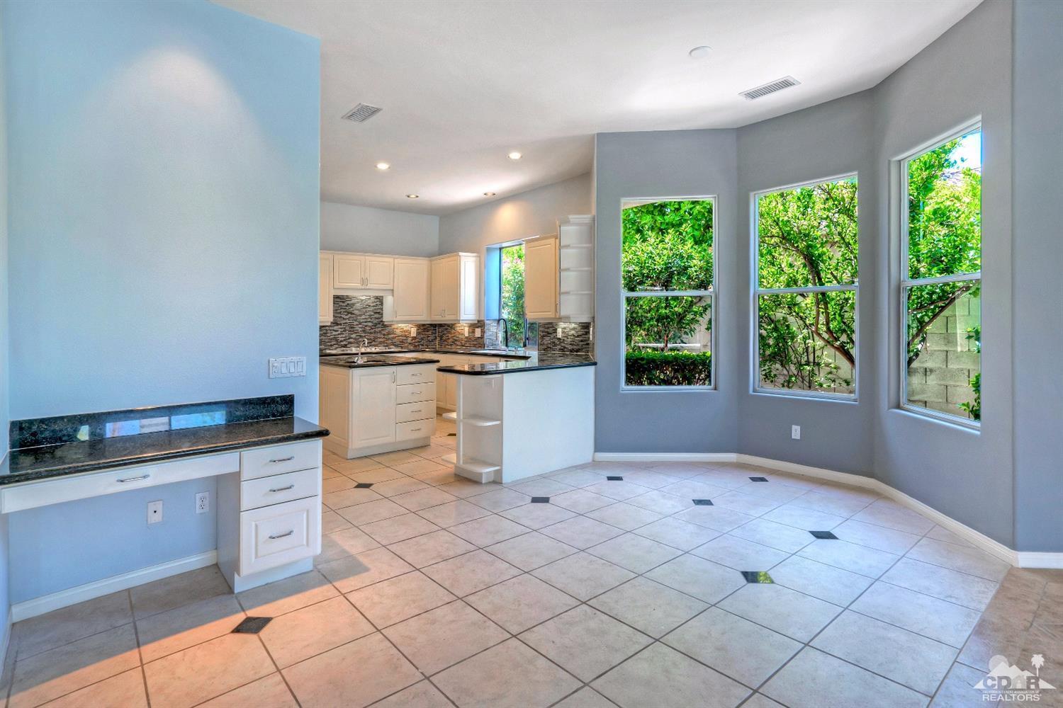 52 Sherwood Road Rancho Mirage, CA 92270 - Photo 9 of 25 a kitchen with stainless steel appliances granite countertop a stove a sink and a microwave