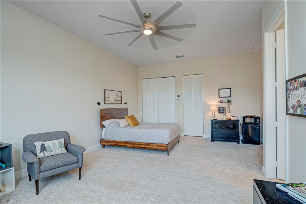 5344 Allen Place Ave Maria, FL 34142 - Photo 24 of 43 En Suite Oversized Bedroom #5 featuring multiple closets, light colored carpet, and ceiling fan