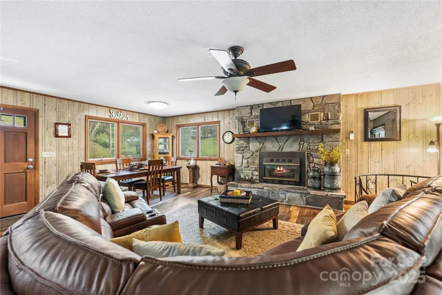 a living room with furniture kitchen view and a large window