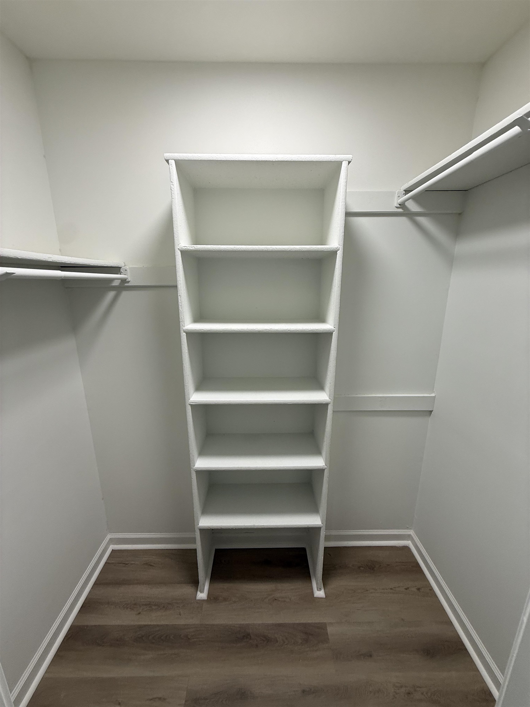 6913 Snyder Road Memphis, TN 38141 - Photo 17 of 20 Custom closet shelving with wood-finish flooring, white walls, and bright overhead lighting