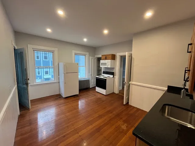 a view of a kitchen with a sink and a refrigerator