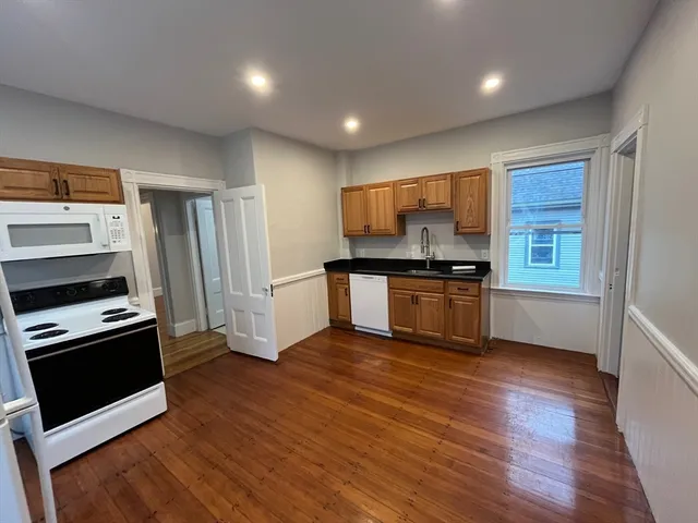 a kitchen with granite countertop a refrigerator and a stove top oven