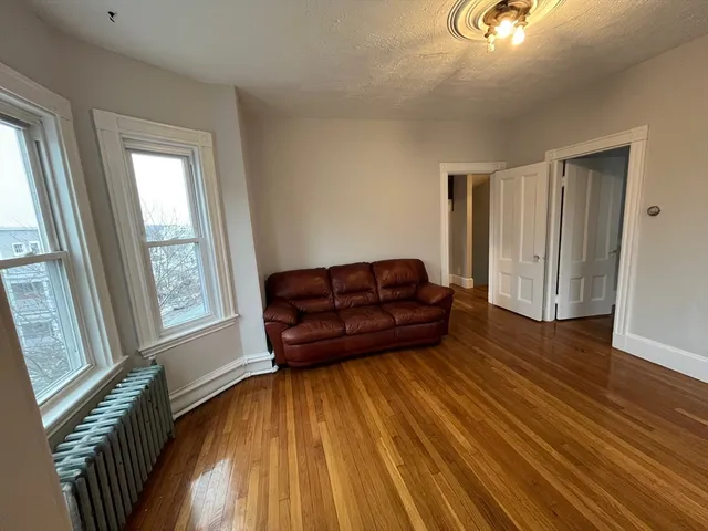 a living room with a couch and wooden floor