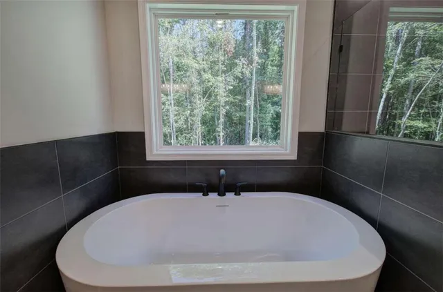 a white bath tub sitting in a bathroom next to a window