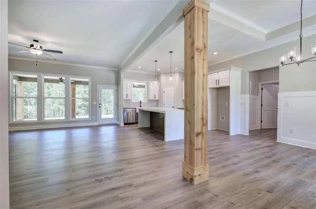 a view of empty room with wooden floor and windows