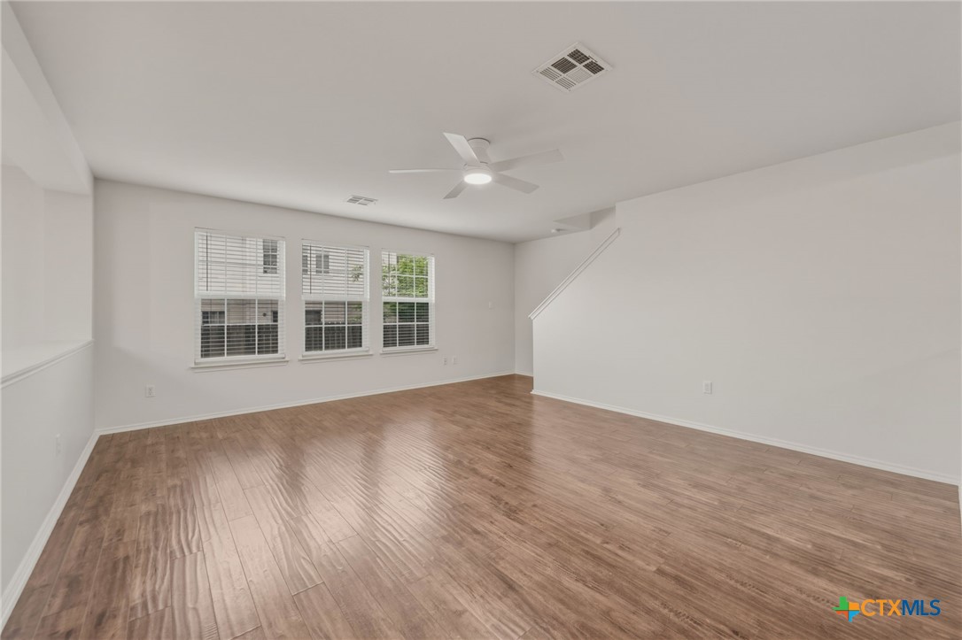 109 Comal Cove Elgin, TX 78621 - Photo 7 of 34 a view of an empty room with wooden floor and a window